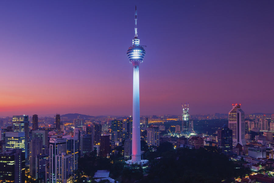 a telecommunication tower standing tall in the city with a purple skyline