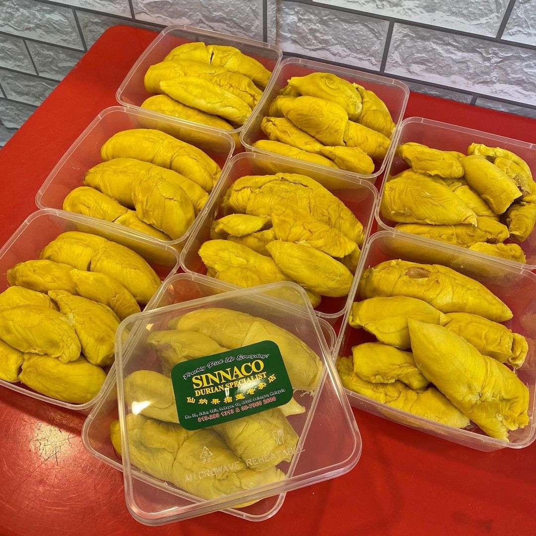 bright yellow durians packed in transparent plastic boxes
