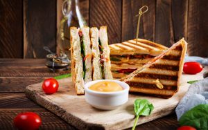 sandwiches served with sauce on a wooden board