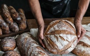 a man holding a baked sourdough