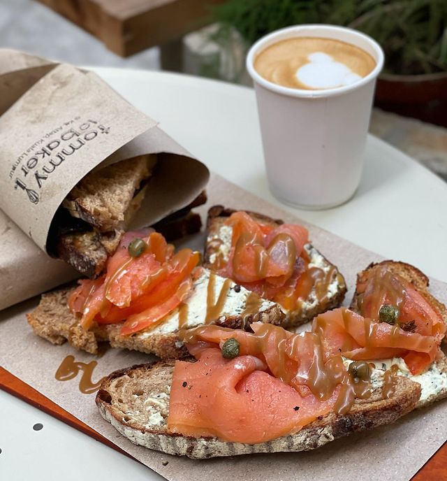 slices of salmon served on sourdough bread with a cup of hot coffee