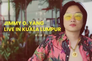 a man with long hair wearing a yellow sunglasses and an unbuttoned Hawaiian t-shirt
