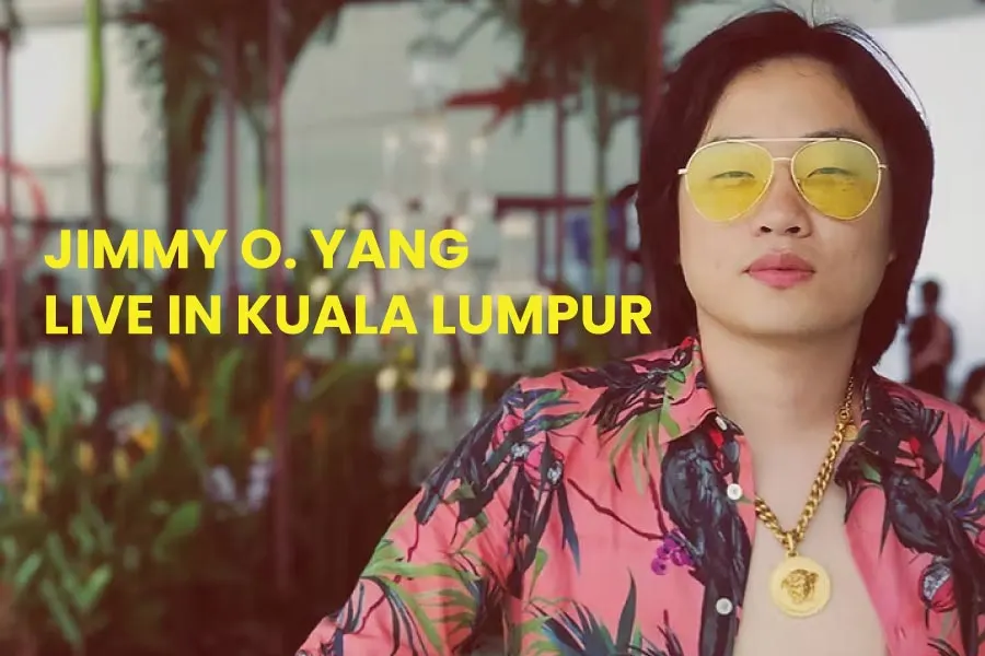 a man with long hair wearing a yellow sunglasses and an unbuttoned Hawaiian t-shirt