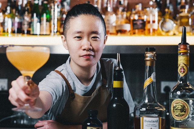 A bartender behind a cocktail bar counter