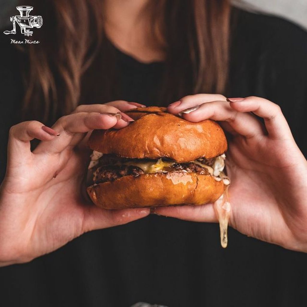 a lady holding a burger with both hands