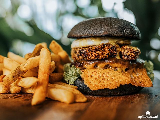 burger with a charcoal bread with french fries