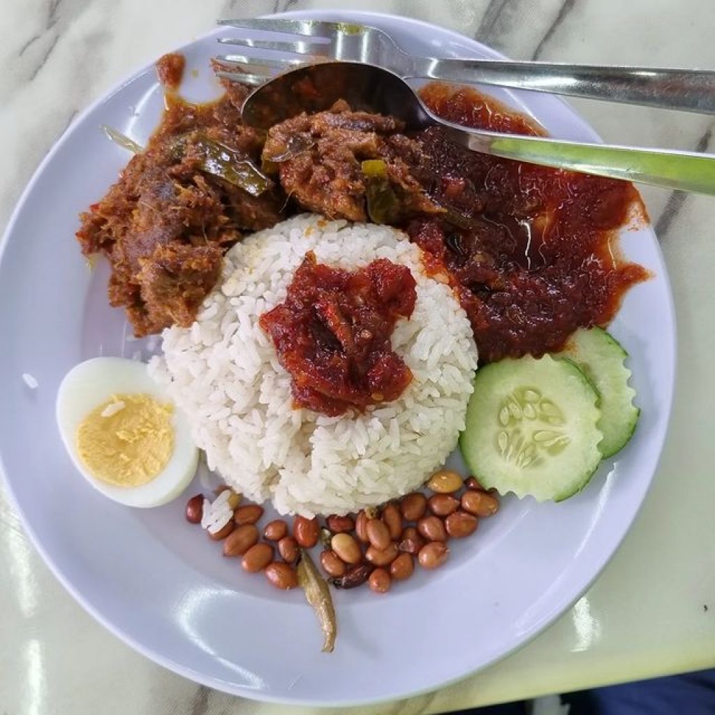 Nasi lemak with fried anchovies, peanuts, hard-boiled egg, fresh cucumber and curry