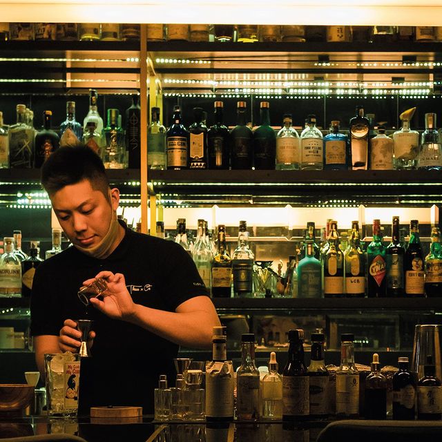 A mixologists crafting a cocktail drinks behind the cocktail bar