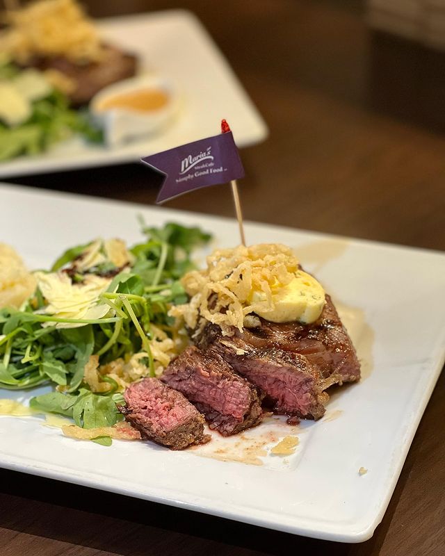 sliced steak served with salad on a white plate