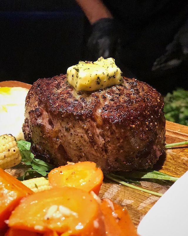 a piece of juicy grilled steak served with salads