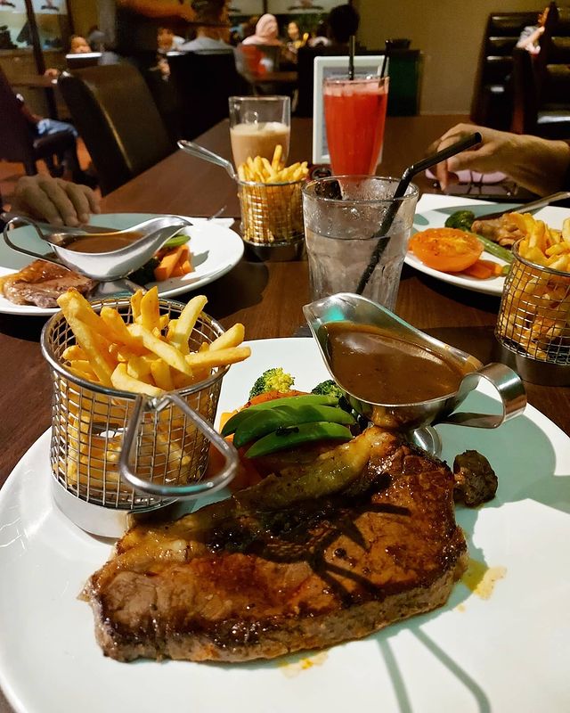 grilled steak served with vegetables and french fries