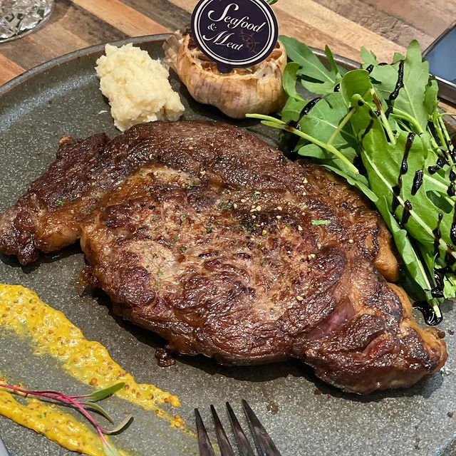 grilled steak served with fresh vegetables, garlic and mashed potato