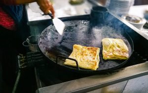 man cooking roti canai