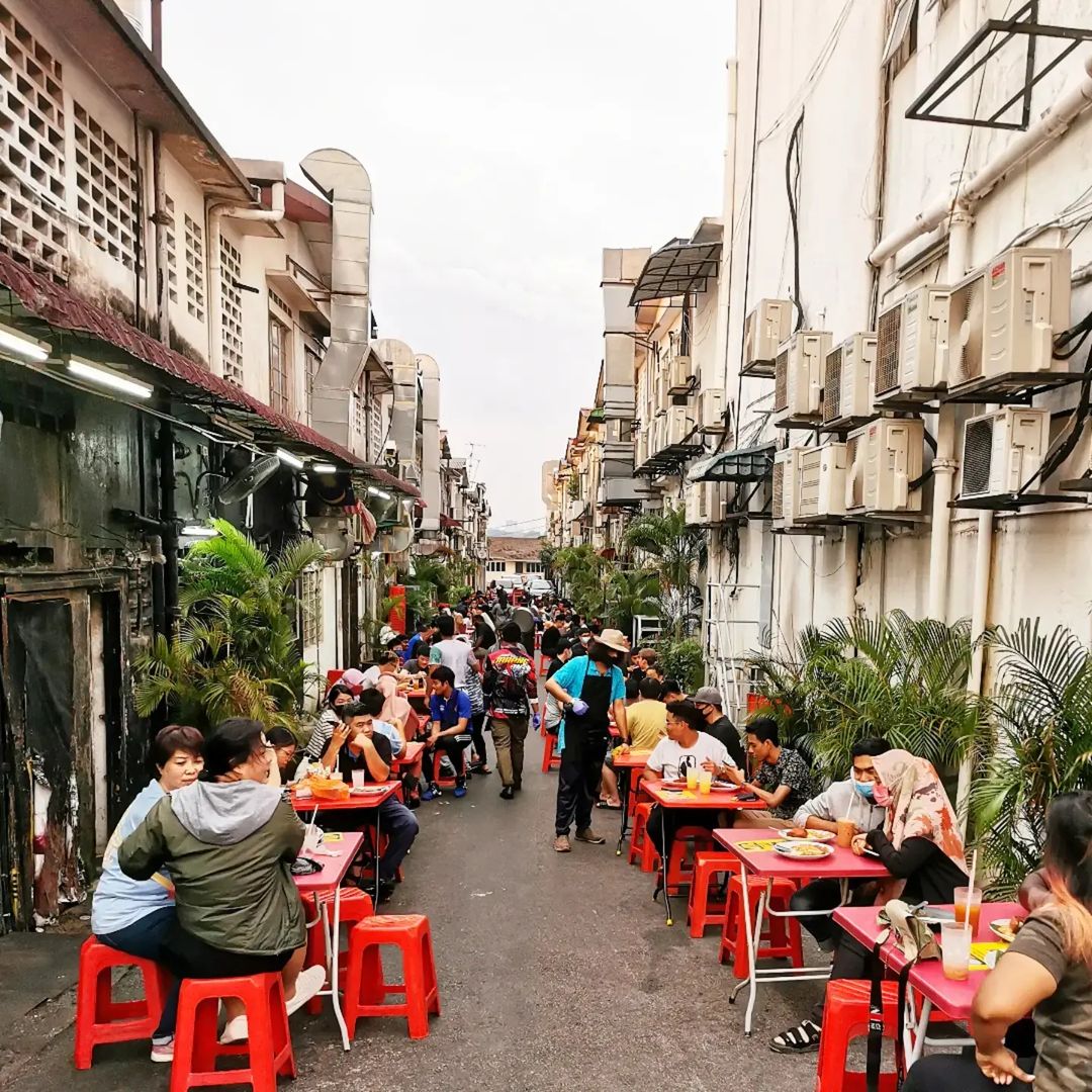people sitting and dining along a back alley