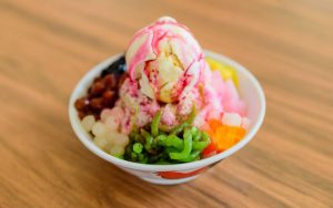 a bowl of dessert with shaved ice, red beans and ice cream