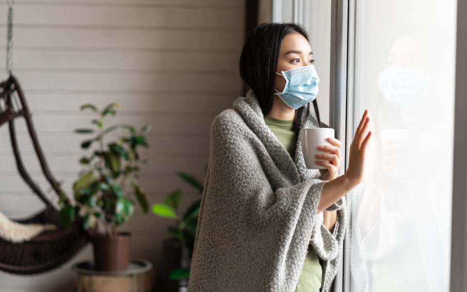 Asian girl wearing mask while staying indoors