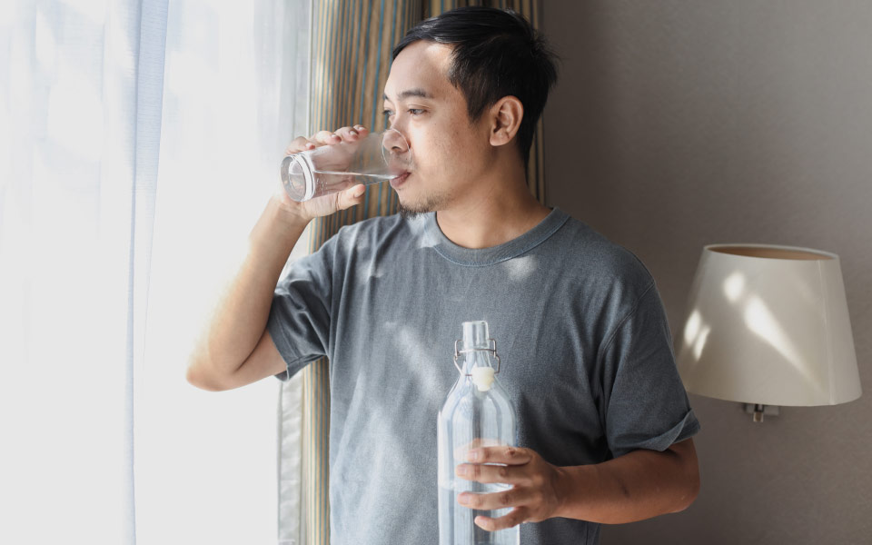 Asian man drinking water to stay hydrated