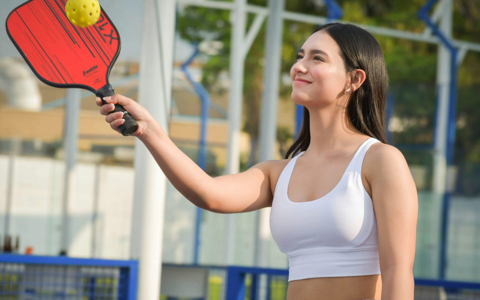 a woman holding a pickleball racquet