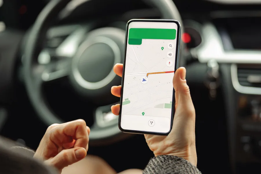 hands holding a mobile phone with apps in the car
