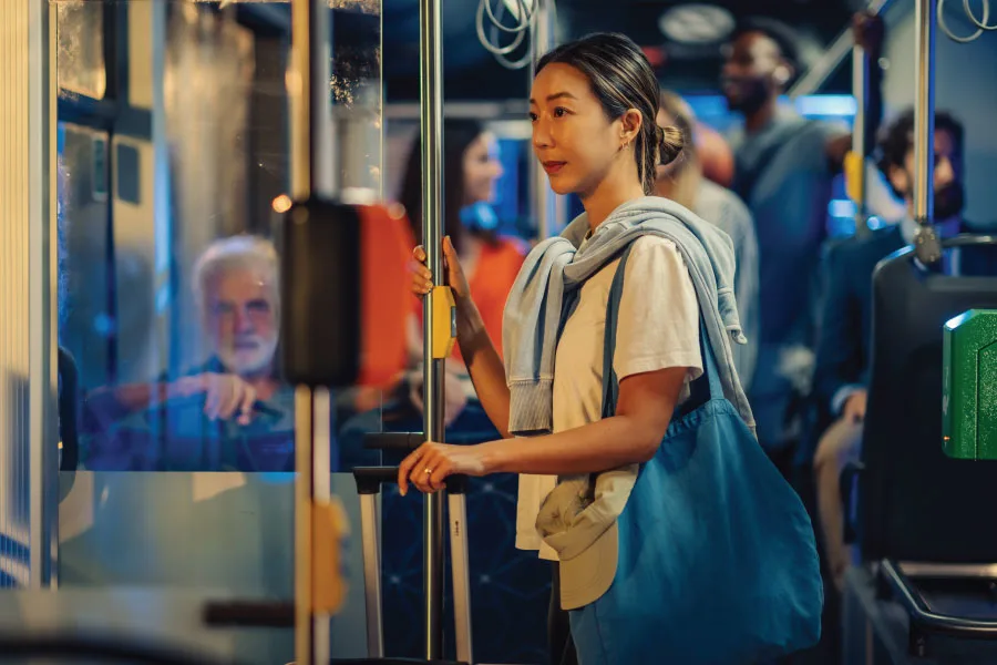 young woman holding on to handrail of a bus
