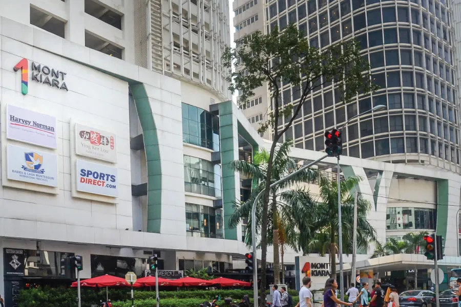 a building with a signage stating 1 Mont Kiara with other advertisement boards