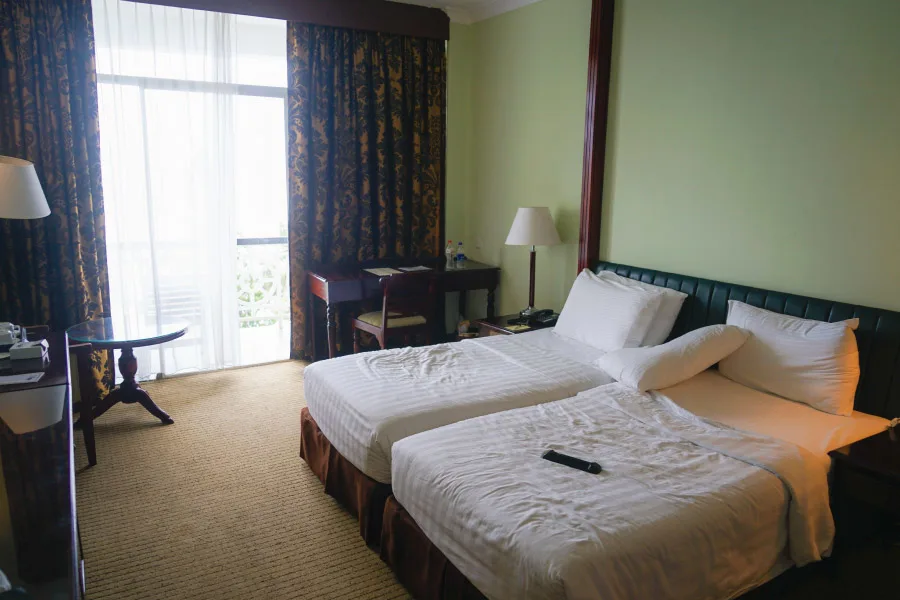 hotel room with two beds and a table with lamp