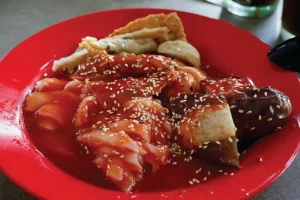 Chee Cheong Fun with sauce served on a red plate