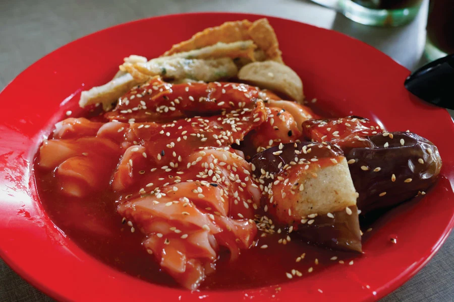 Chee Cheong Fun with sauce served on a red plate