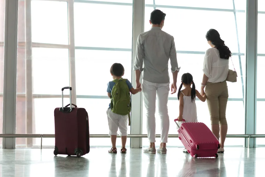 a family with kids with luggages waiting at the airport
