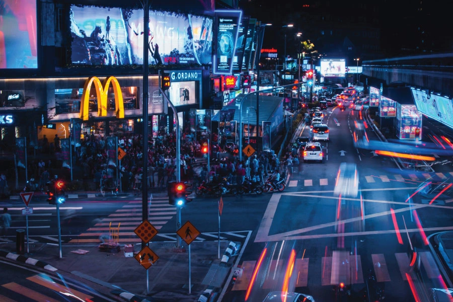 night scene at a street with crowds and city lights