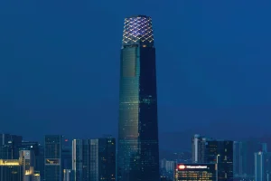 a skyscraper amongst other buildings in a blue sky background