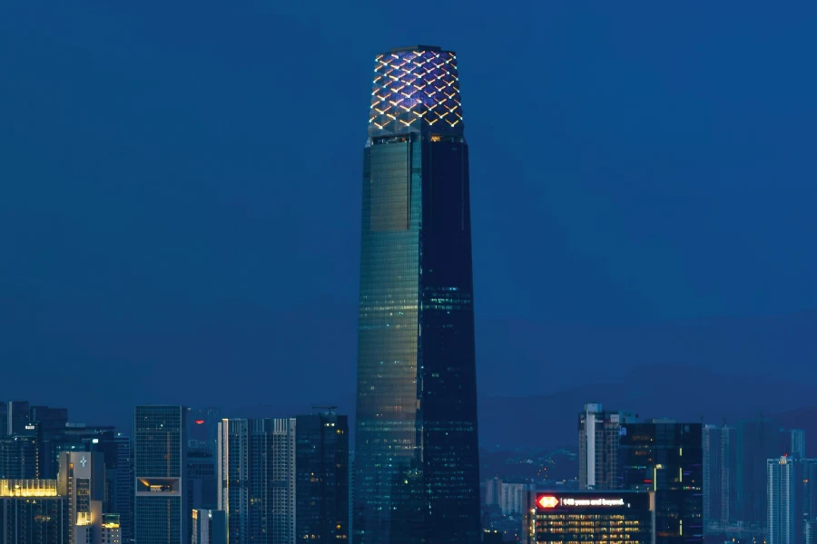a skyscraper amongst other buildings in a blue sky background