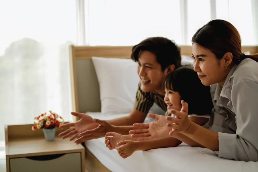 family on the bed together in a hotel