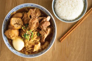 a bowl of meat and other ingredients served with steamed white rice