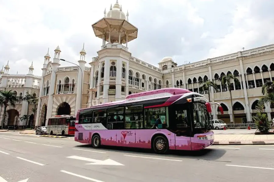 pink colour bus in front of a building with historical architecture