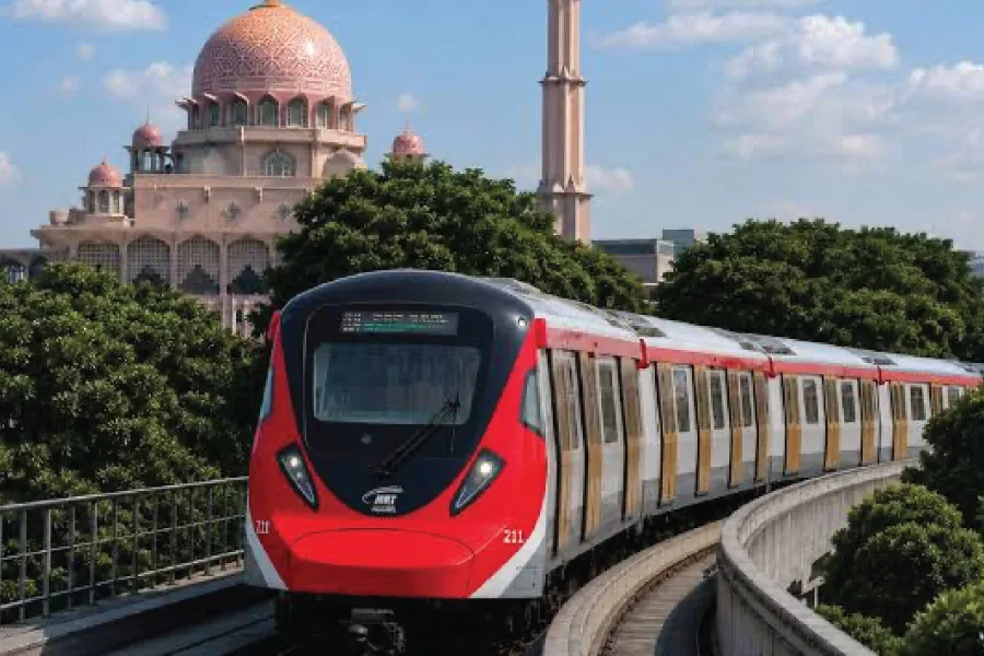 a train on the tracks passing by a pink colour mosque