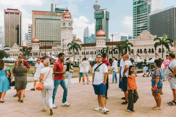 people walking around a space with an old building at the background